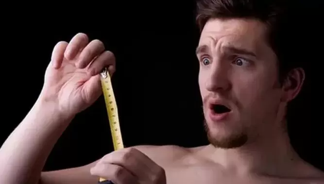 Mann hat seinen Penis vor der Vergrößerung gemessen
